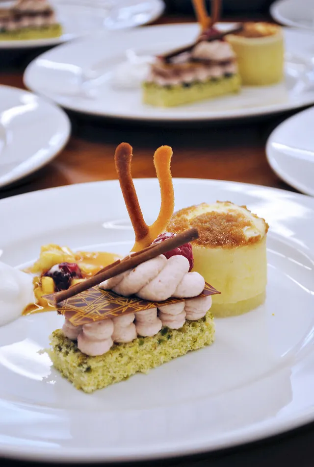 Postre emplatado con crema, chocolate y frutos rojos