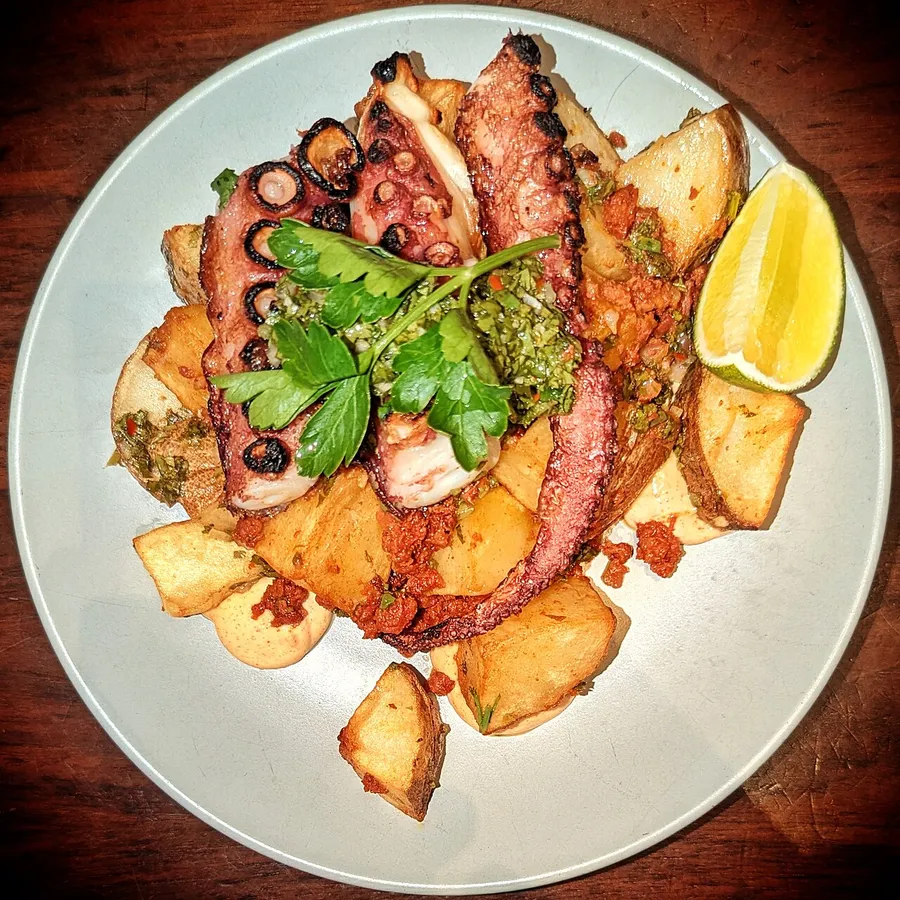 Pulpo a la parrilla con papas, hierbas y limón
